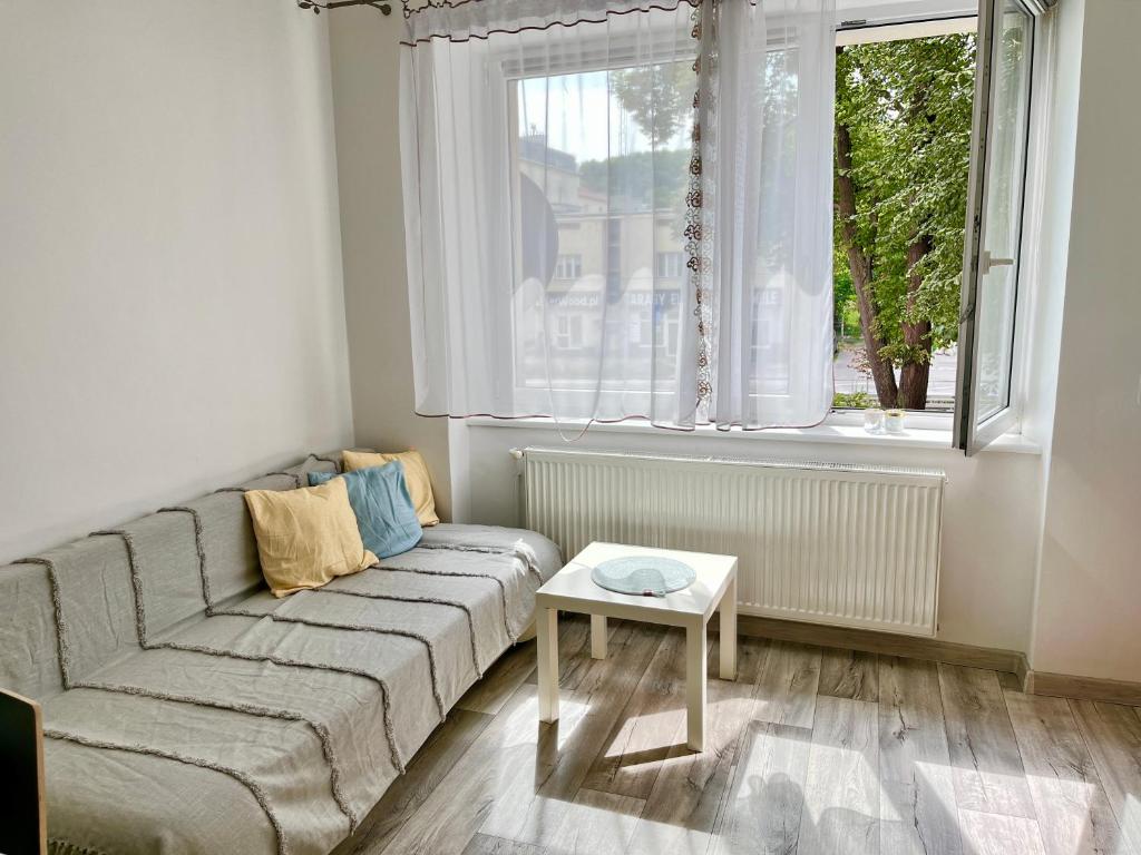sala de estar con sofá y ventana en Luff Gdynia Morska, en Gdynia