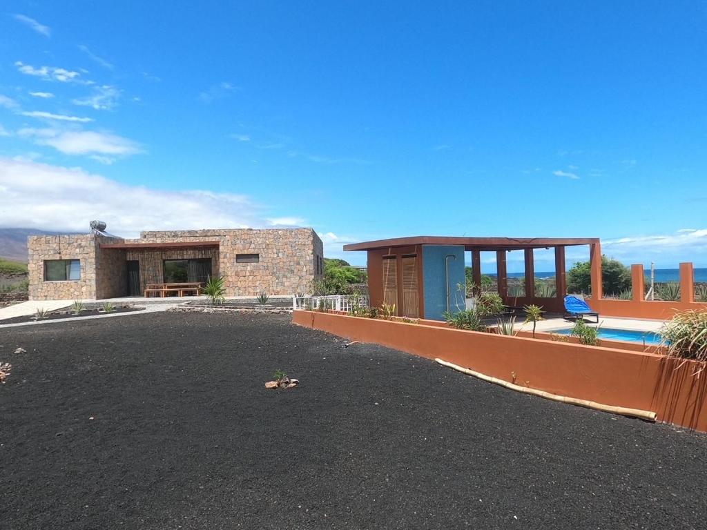 uma casa de tijolos com uma piscina em frente em Vila Babosa em Porto Novo