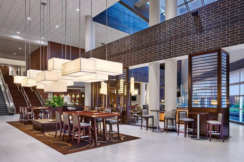 un restaurante con mesas y sillas en un edificio en Sheraton Indianapolis Hotel at Keystone Crossing, en Indianápolis