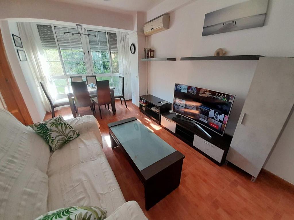 a living room with a couch and a tv and a table at CALZADA Homes in Almería