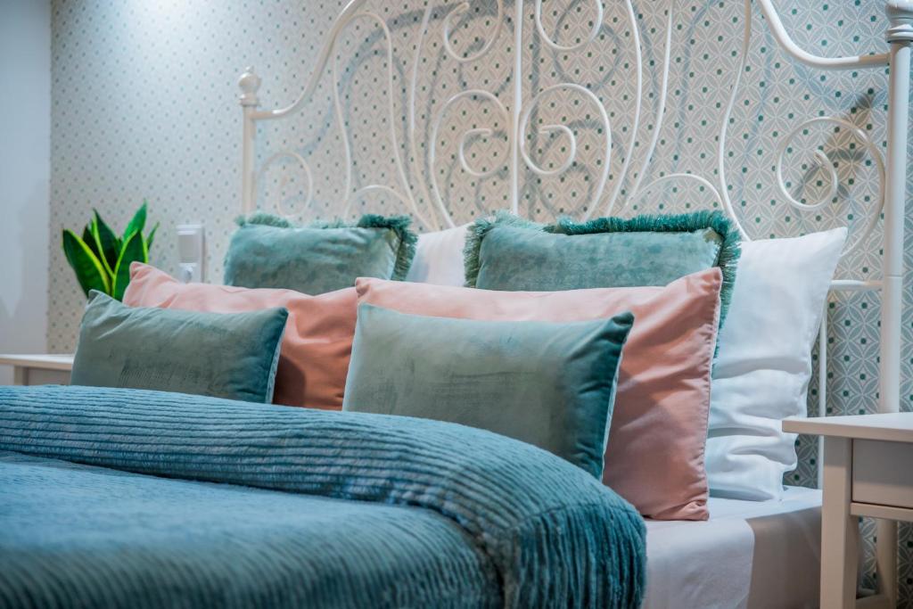 a bed with blue and pink pillows on it at Harmony Boutique Hotel in Drawsko Pomorskie