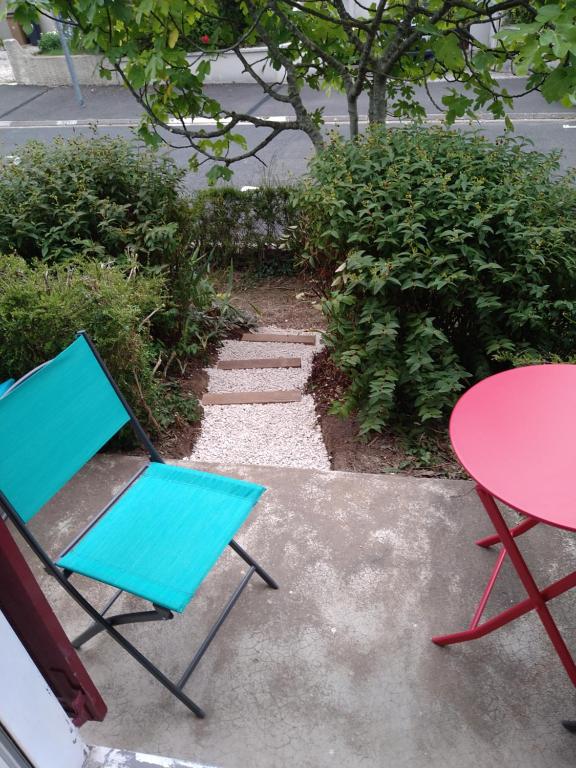 einen blauen Stuhl, einen roten Tisch und einen Tisch in der Unterkunft hauts des 2 lions -studio in Joue-les-Tours