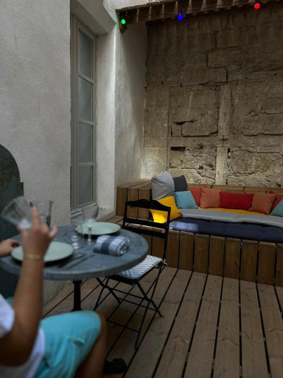 a room with a table and chairs and a couch at Mes à Moi in Pezenas - Studio &amp; patio privatif - O Pitchoun in Pézenas