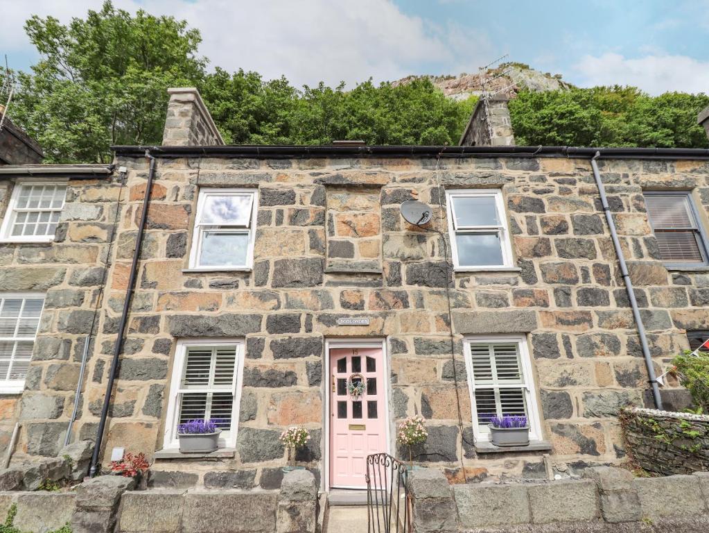 an old stone house with a pink door at Bodlondeb in Porthmadog