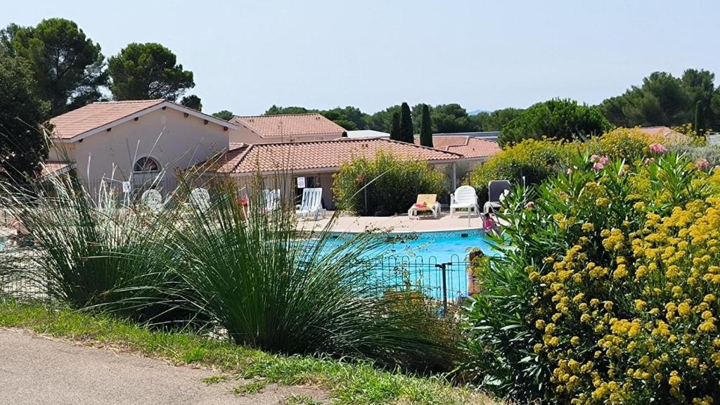 a house with a swimming pool in a garden at Appartement 2 Pièces Le Domaine de Manon in Signes