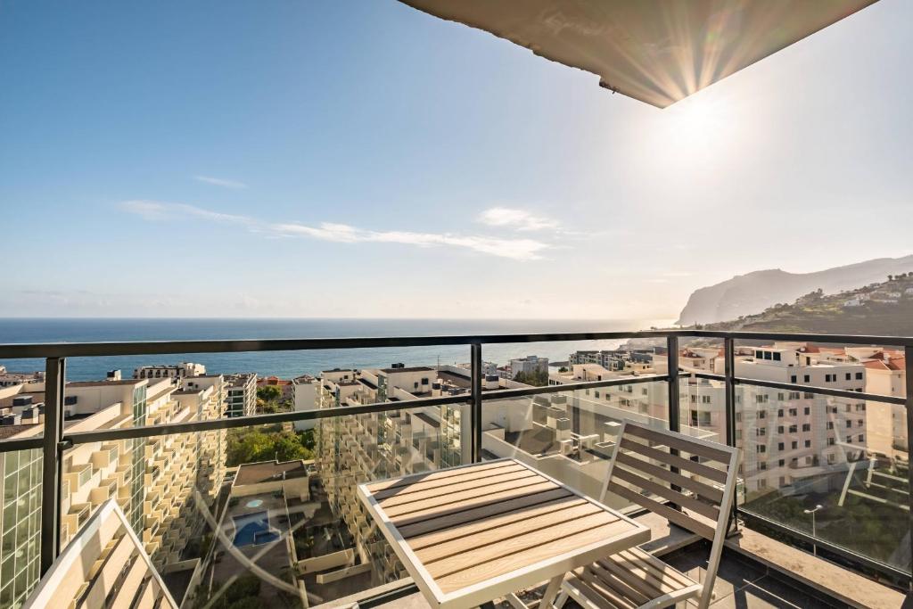 balcón con banco y vistas al océano en Blue and Gold Sunset By Madeira Sun Travel en Funchal