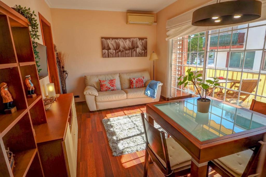 sala de estar con mesa de cristal y sofá en The Beach Apartment by Hello Homes Sitges, en Sitges