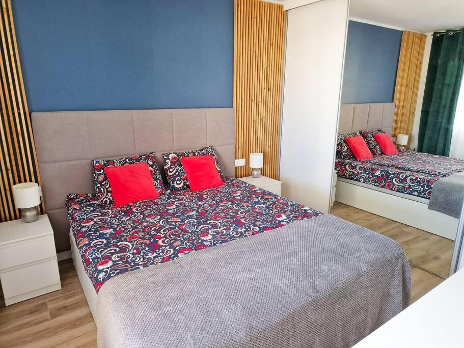 een slaapkamer met 2 bedden en rode kussens bij Ekskluzywny,przytulny,widok na ocean,duży taras in Adeje