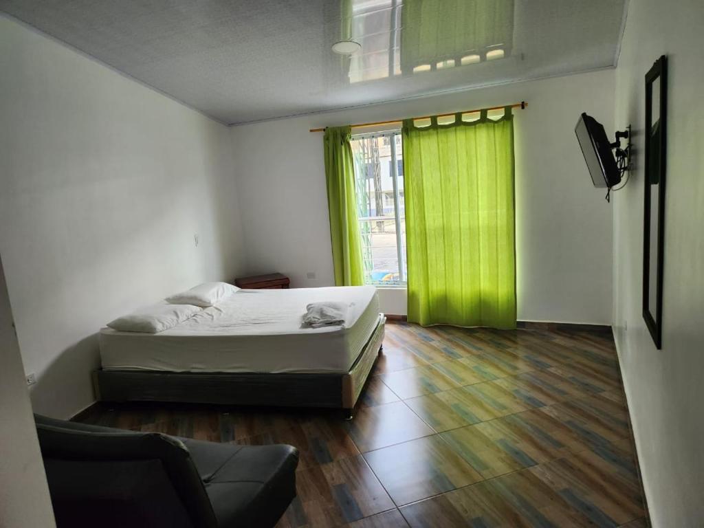 een slaapkamer met een bed en een groen gordijn bij aparta estudio in Cocorná
