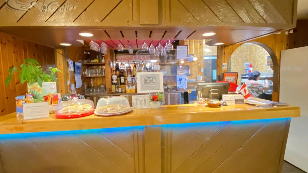 Un bar con un mostrador con comida encima. en Rolphton Motel and Restaurant, en Moor Lake Station