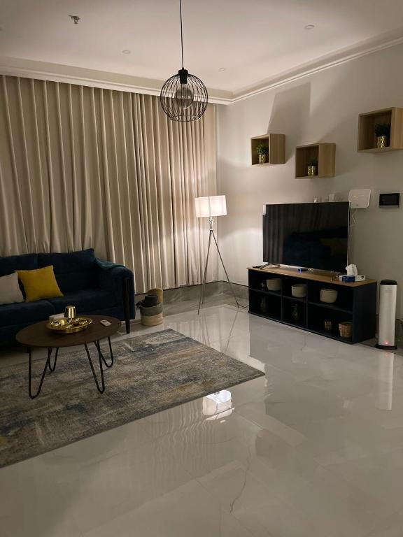 a living room with a couch and a table at Family Furnished Apartment in Khobar in Al Khobar