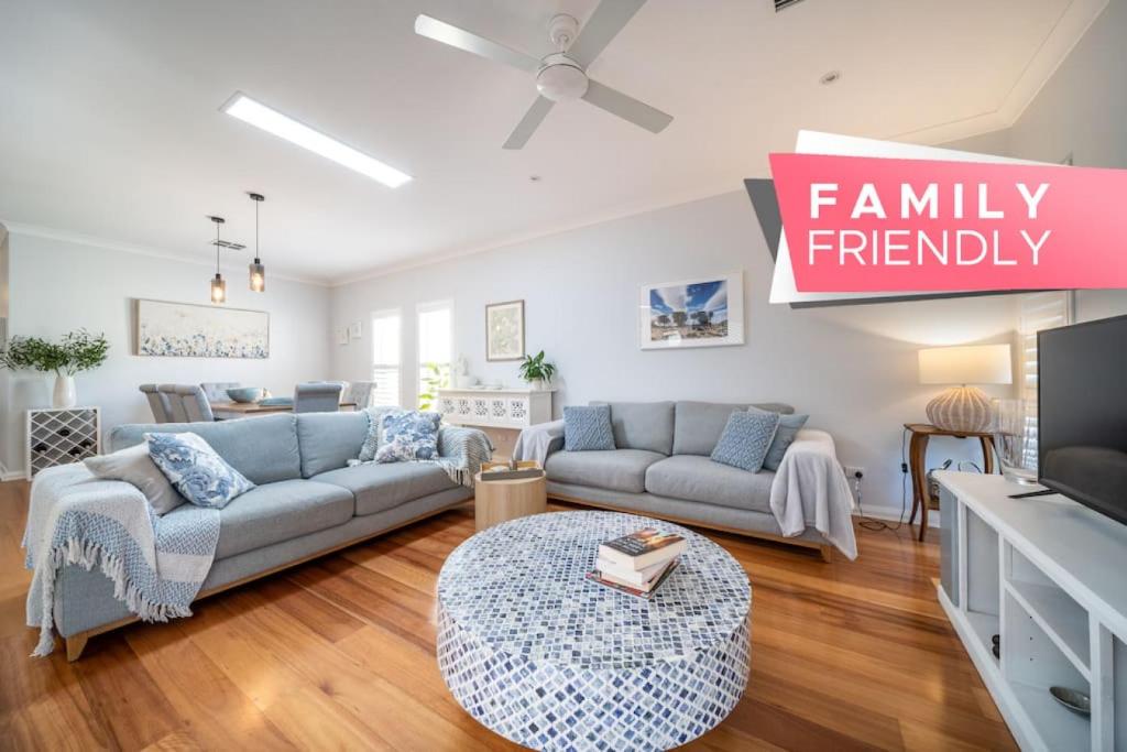 a living room with a couch and a tv at Azure on Anderson Family home in Henley Beach South