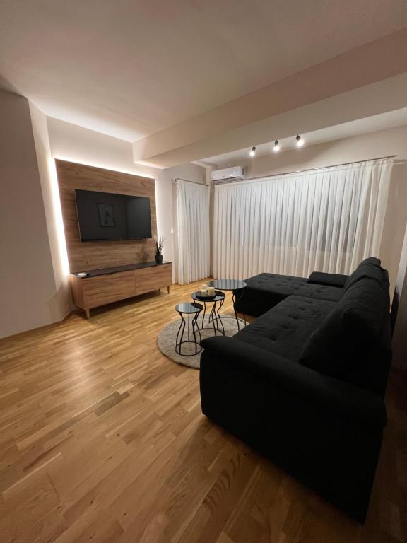 a living room with a black couch and a flat screen tv at Apartment33 in Strumica