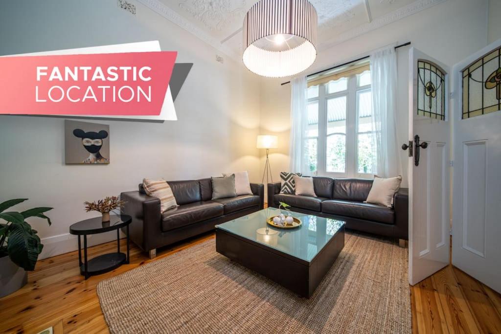 a living room with a couch and a coffee table at The Oxford Hyde Park 4BR Cottage in Unley