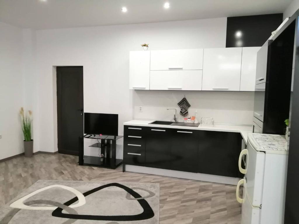 una cocina con armarios blancos y una cocina en blanco y negro en Апартамент ЗАПАД, en Kazanlak