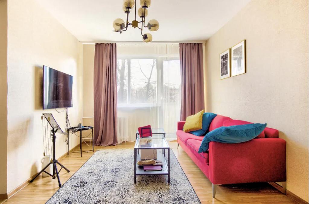 sala de estar con sofá rojo y mesa en Room near downtown and airport en Vilna