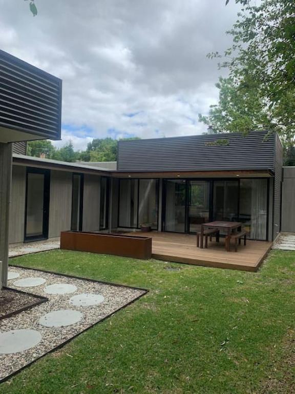 a house with a wooden deck with a picnic table at The Architects House Villa 1 and 2 in Hahndorf