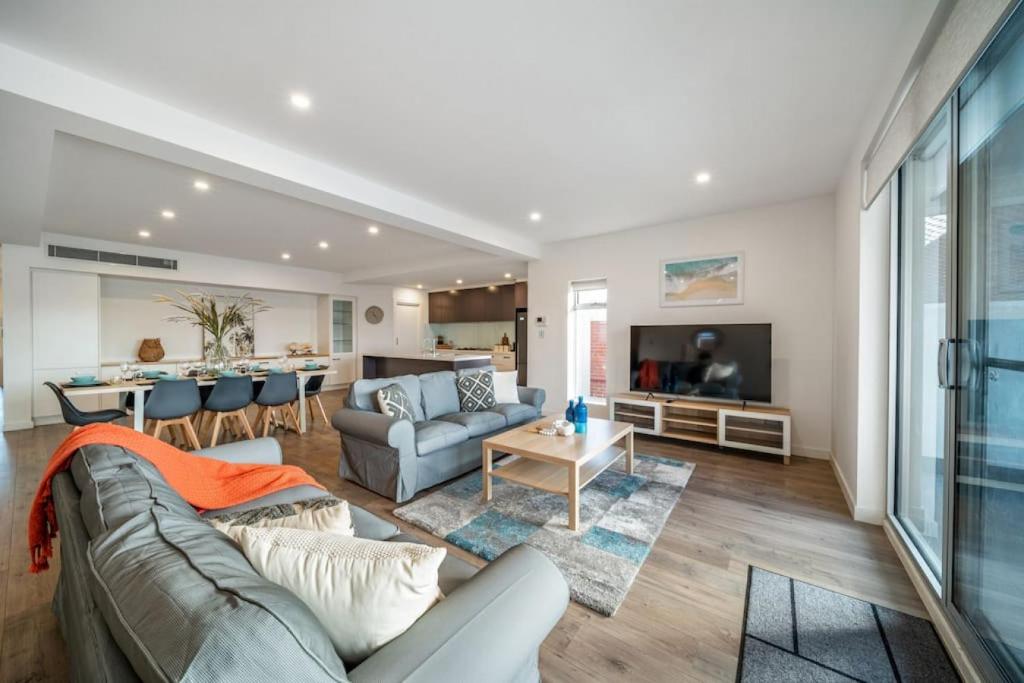 a living room with a couch and a table at Level Up Henley - Modern Comfort near Beach & Dining in Grange