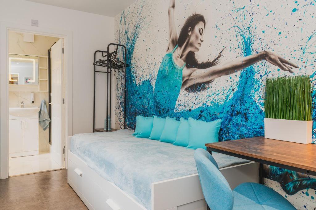 a bedroom with a bed with a painting on the wall at Baila Casa apartments in Nottingham