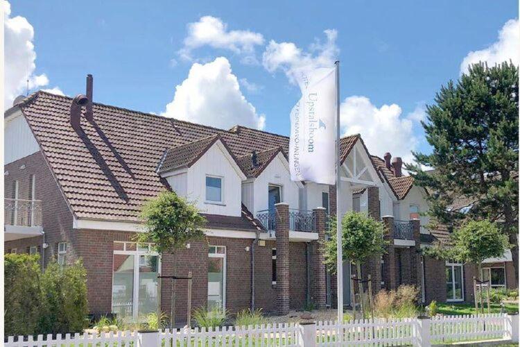 una casa grande con un cartel delante en Discover Langeoog Comfortable apartment with SPA and pool en Langeoog