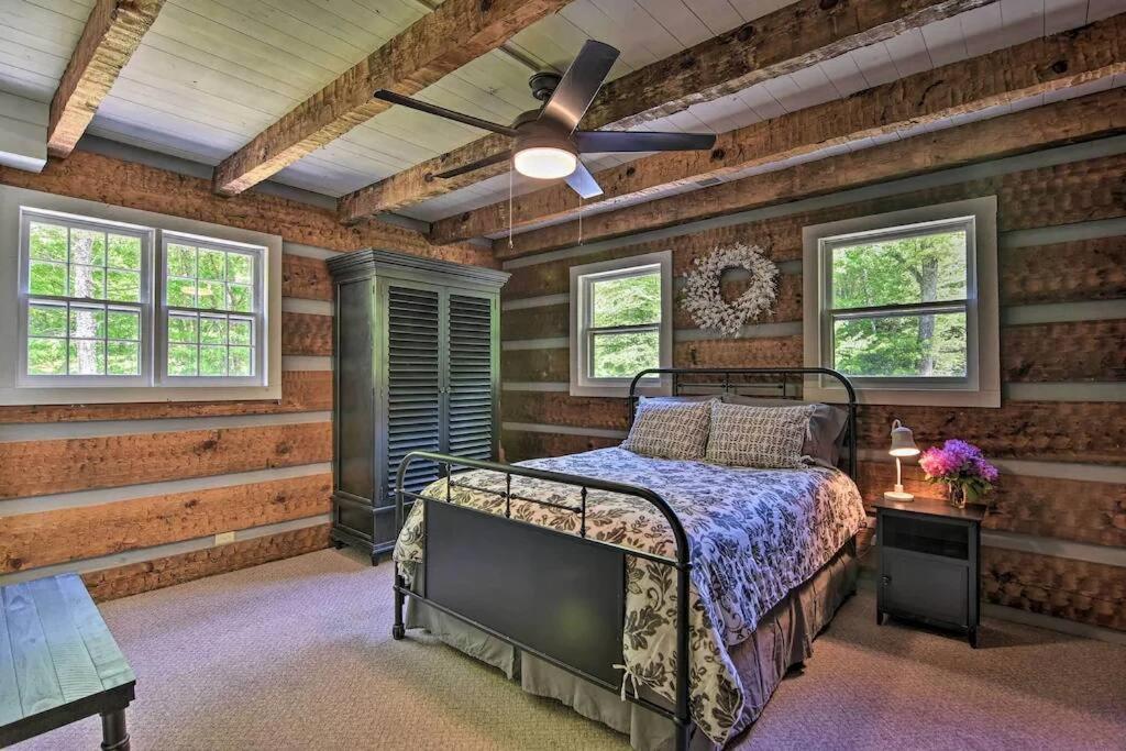 a bedroom with a bed and a ceiling fan at Creekside cabin w/ hot tub, fireplace & trail in Newland