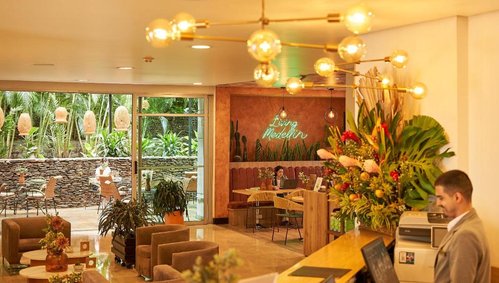 a man sitting at a table in a restaurant at Hotel Poblado Alejandria in Medellín