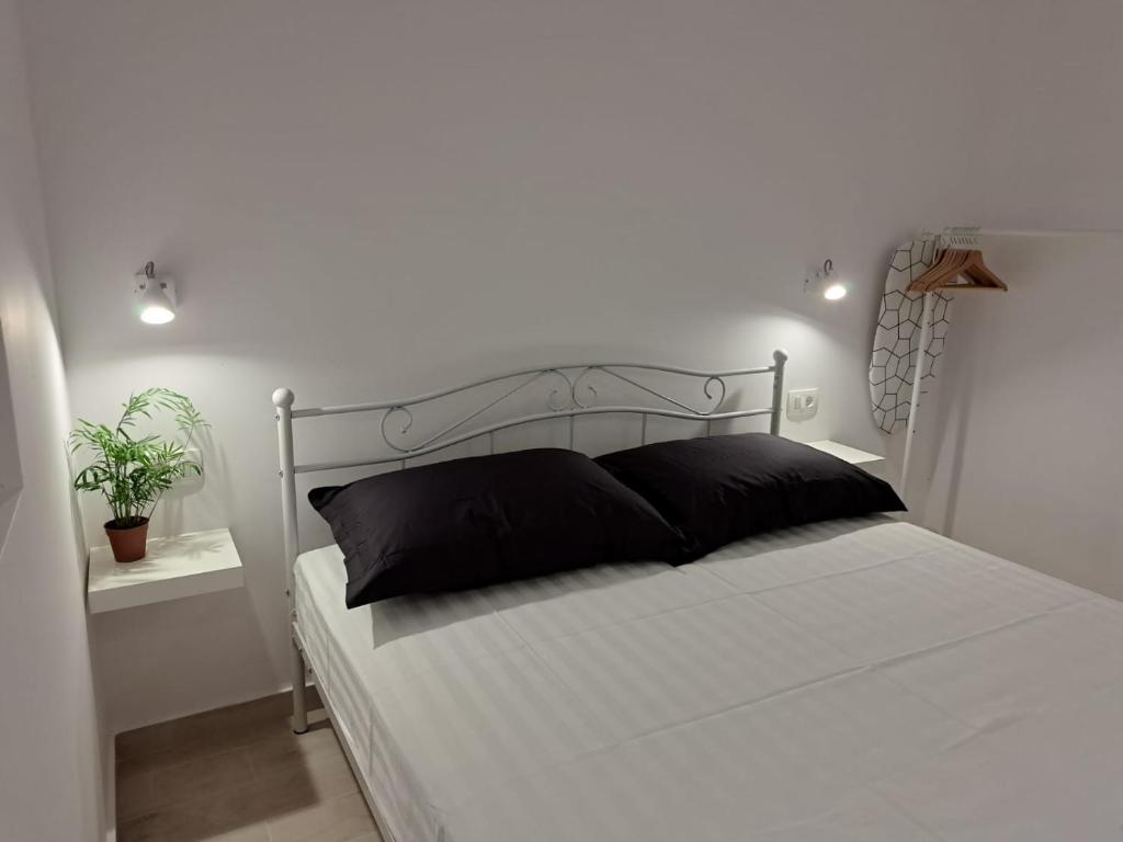 een wit bed met zwarte kussens in een slaapkamer bij Sea view in Hvar
