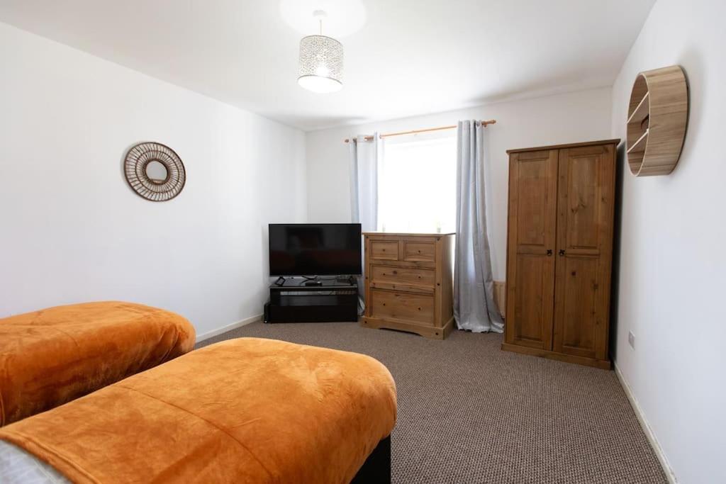 a bedroom with two beds and a flat screen tv at Ideal home with private parking for contractors & groups in Birmingham