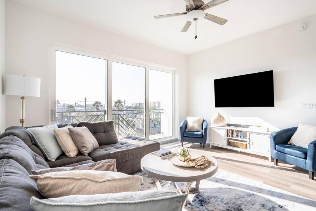 a living room with a couch and a tv at 5 Star Luxury Beach Condo-Anchor Oasis in St Pete Beach