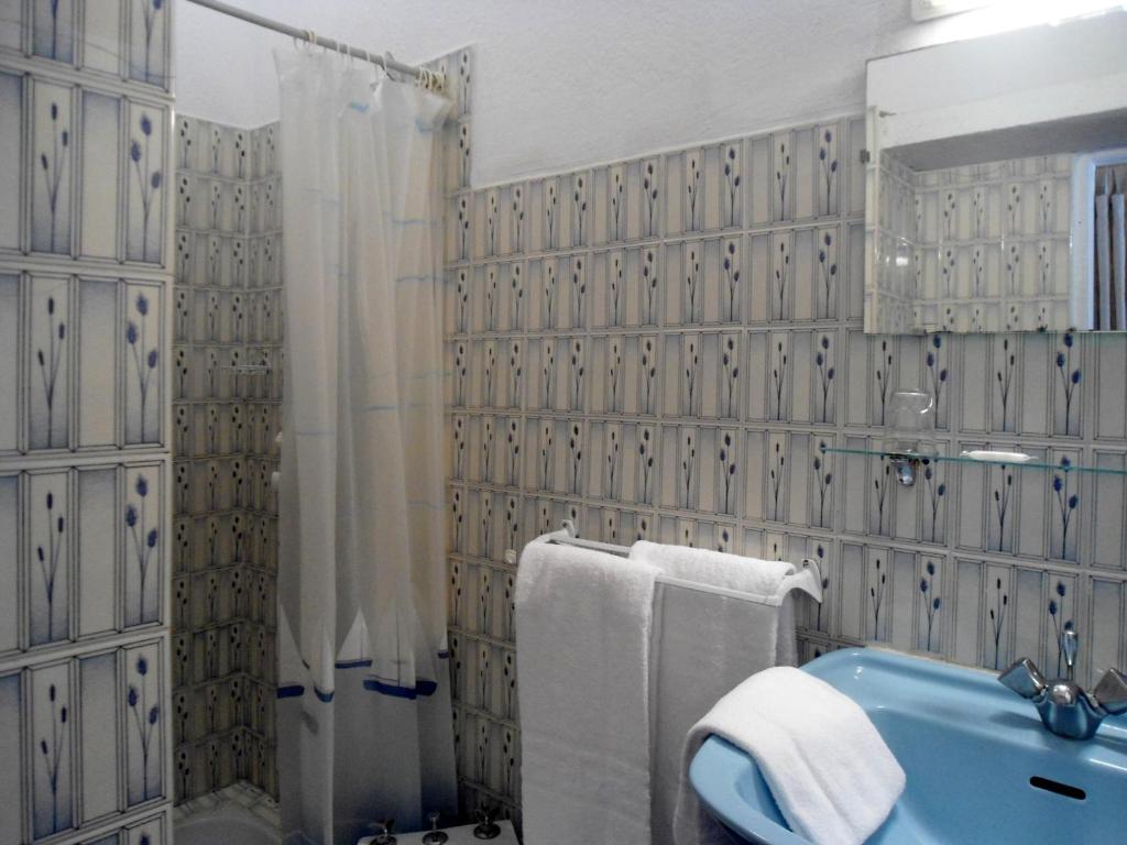 Un baño con un lavabo azul y una ducha. en Hotel Les Calanques, en Piana