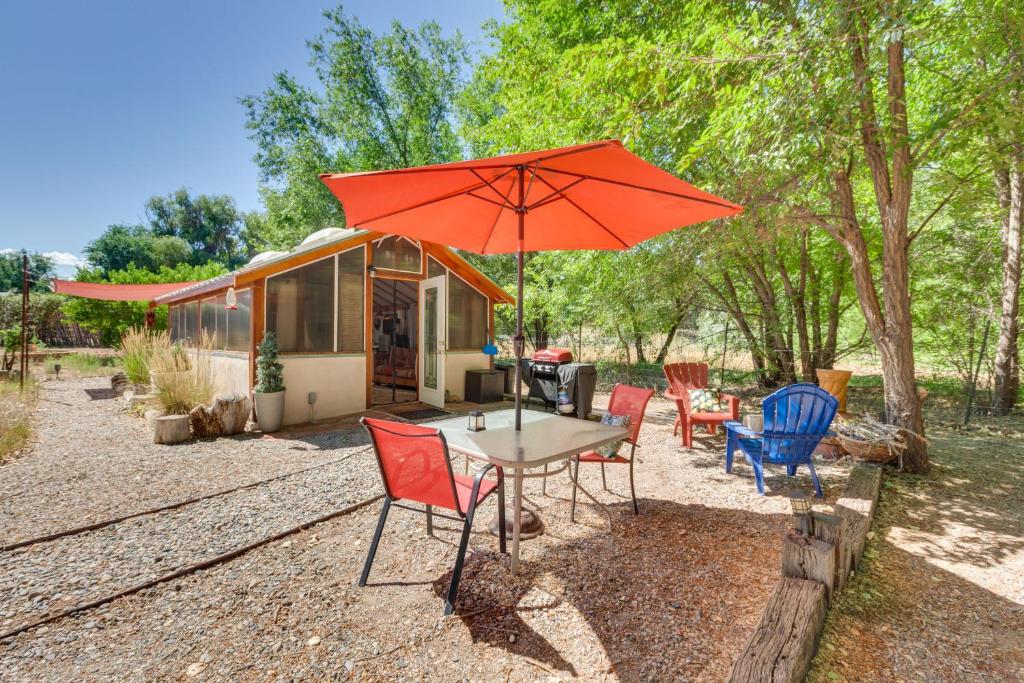 un tavolo con sedie e un ombrellone di fronte a una roulotte di Cozy Santa Fe Getaway - Near Creek and Casinos a Pojoaque