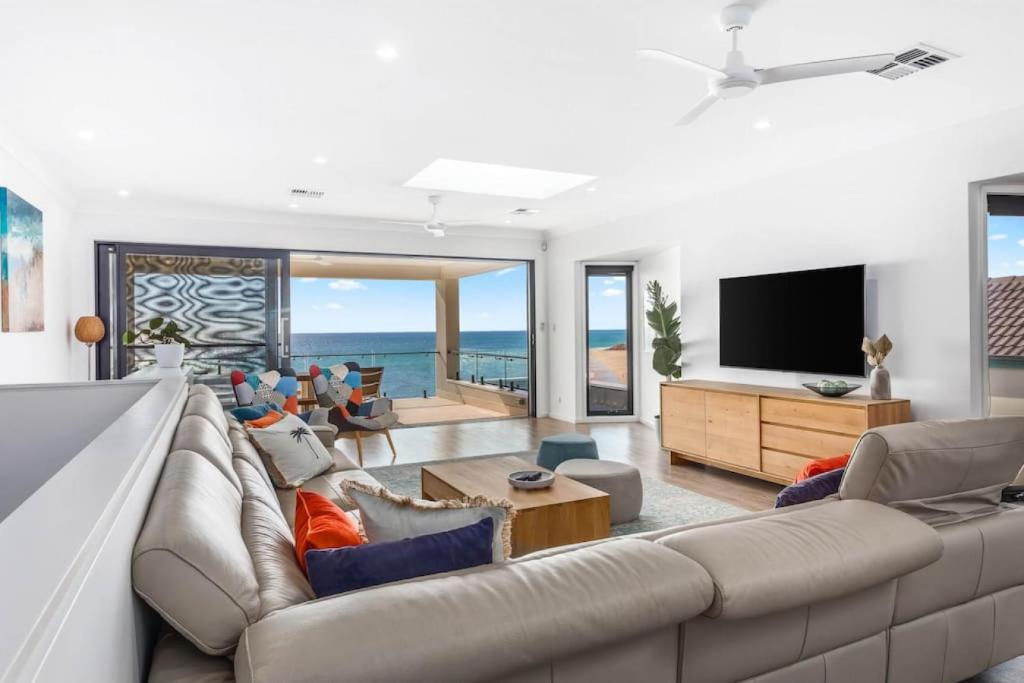 a living room with a couch and a flat screen tv at Seascape Christies Ocean Views in Christies Beach