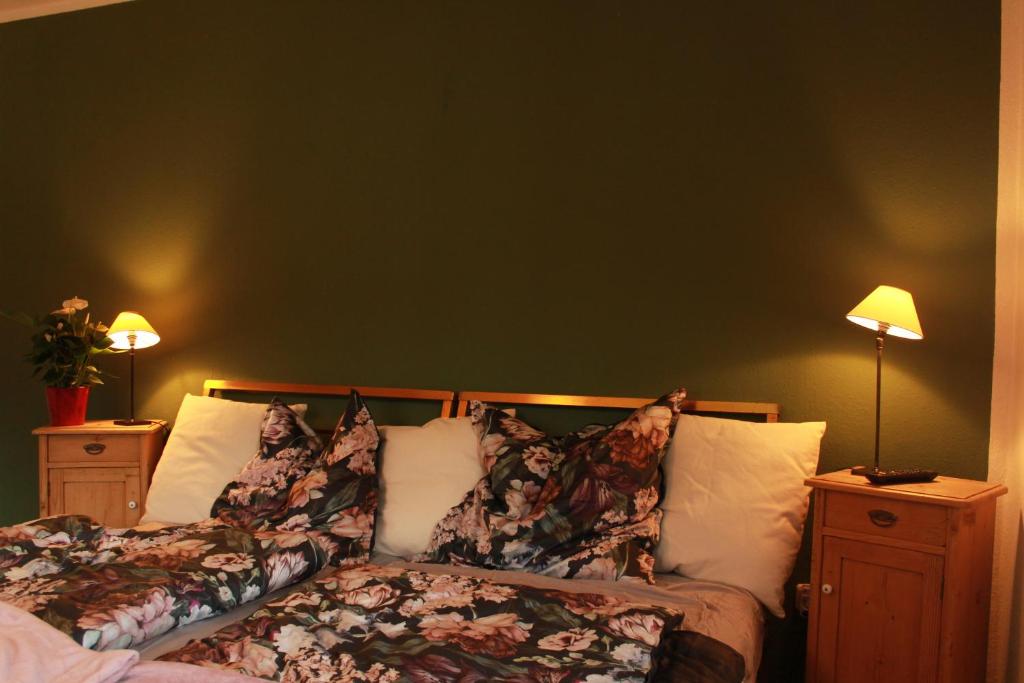 1 dormitorio con 1 cama con almohadas y 2 lámparas en Ferienwohnung CONNI en Hellenthal