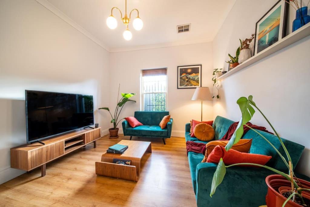 UnleyThat 70s Cottage Parkside Cottage Backyard WiFi的客厅里有一张沙发和一台电视
