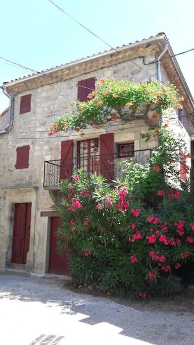 un bâtiment avec des fleurs sur son côté dans l'établissement Maison proche rivière - 6 à 8 personnes, à Chambonas