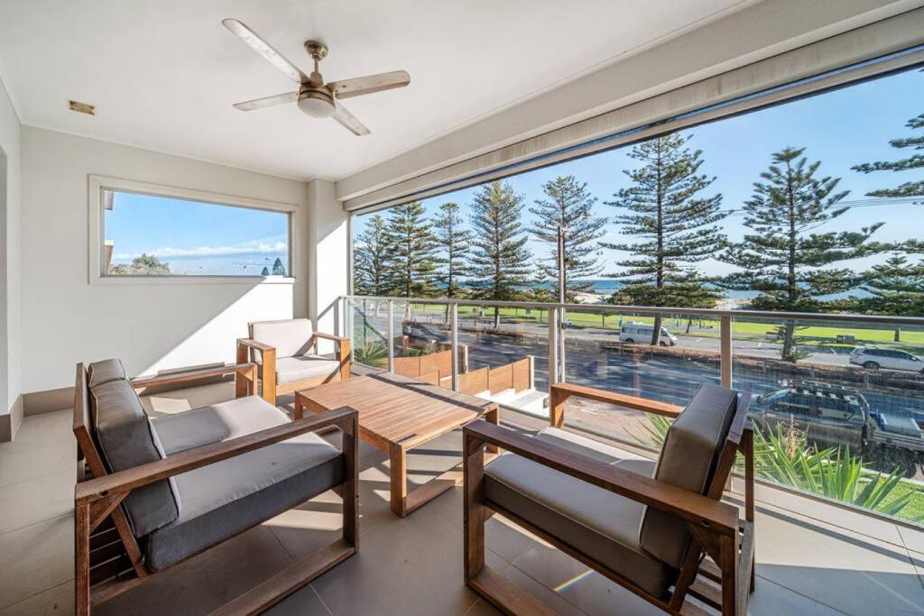 a living room with a table and chairs and a large window at Beach Haven at Semaphore - Sweeping Ocean Views in Port Adelaide
