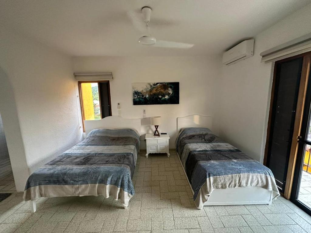 a bedroom with two beds and a window at Cómodo Depa en Club Santiago in Manzanillo