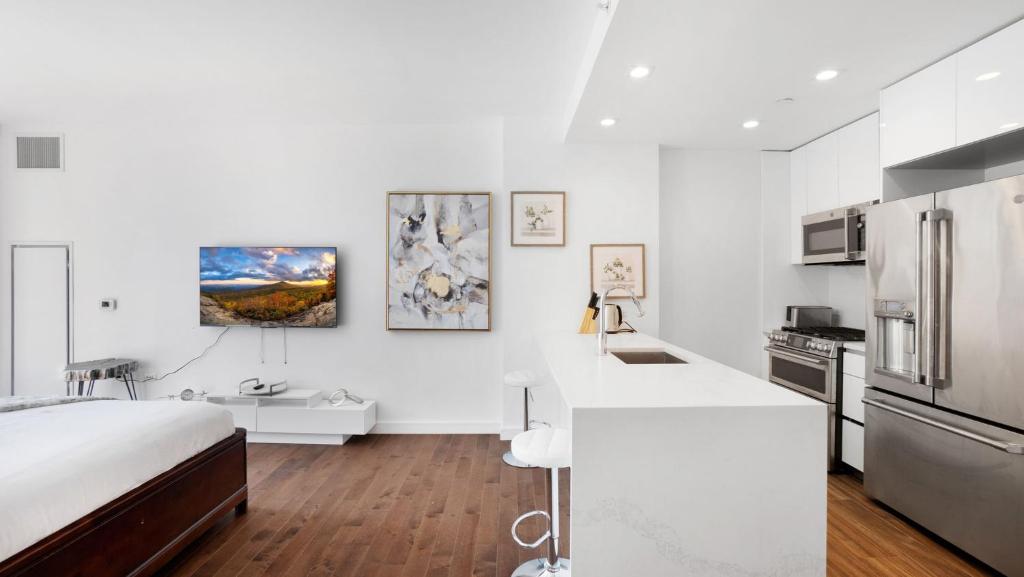a white kitchen with a bed and a white counter top at Lux 2 Bedroom 1 Bath Suite in Hudson Yards in New York