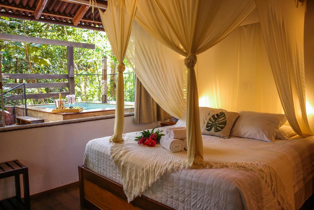 um quarto com uma cama de dossel e uma janela em Villa Arumã Pousada em Alter do Chão