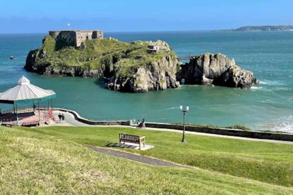 a park with a bench and an island in the water at 5 min walk to Beaches & Pembrokeshire Coast Path in Pembrokeshire