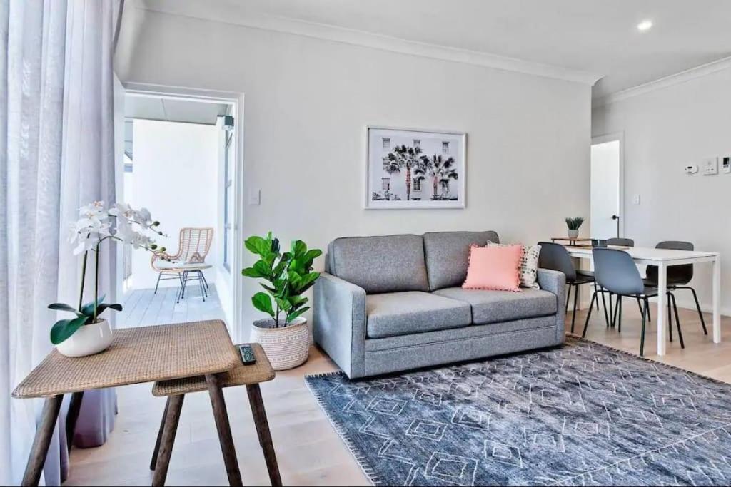 uma sala de estar com um sofá e uma mesa em Bloom at Lotus Apartments em Plympton