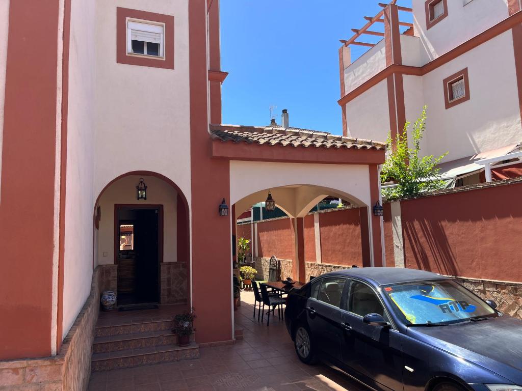 un coche negro estacionado frente a una casa en Casa con piscina cerca de Sevilla, en Sevilla