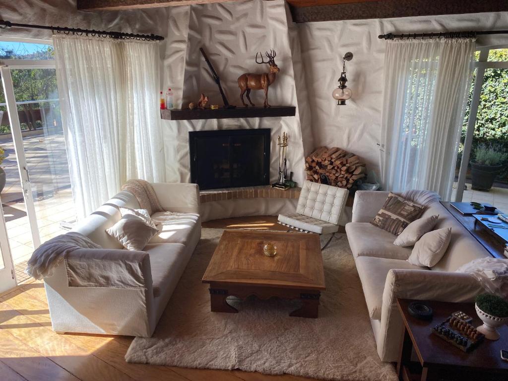 a living room with couches and a table and a fireplace at Casa Campos do Jordão, bairro Capivari, Wi-Fi, churrasqueira e forno de pizza, totalmente equipada in Campos do Jordão