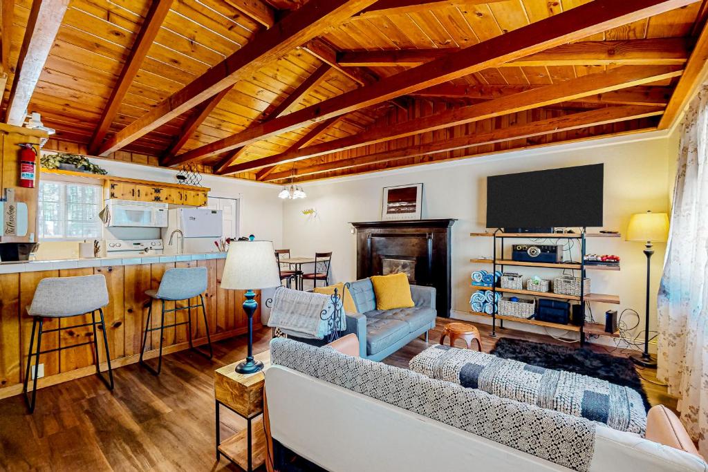 a living room with a couch and a tv and a kitchen at Hounds of Aspen in South Lake Tahoe