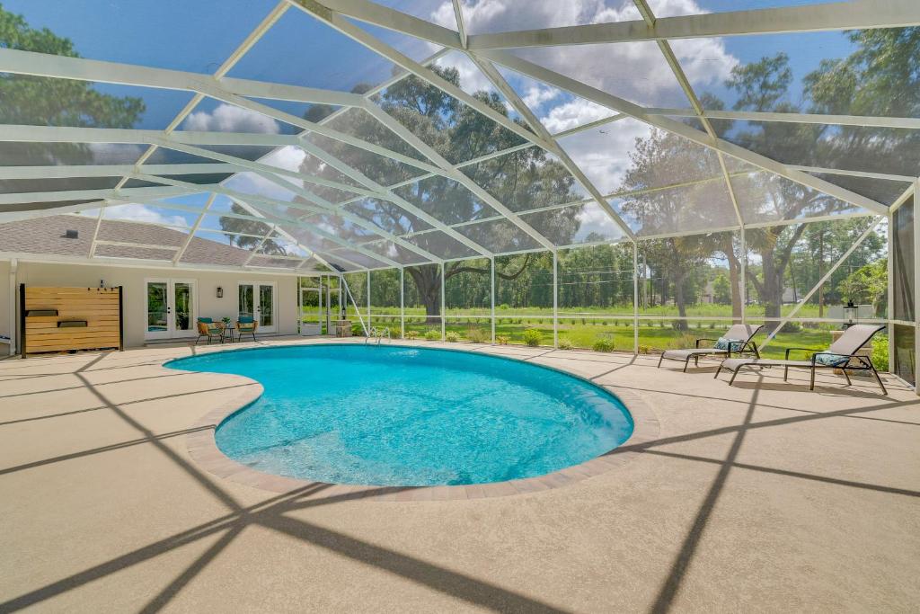 an indoor swimming pool with a glass roof at Cozy Ocala Retreat with Pool, Screened Lanai! in Ocala