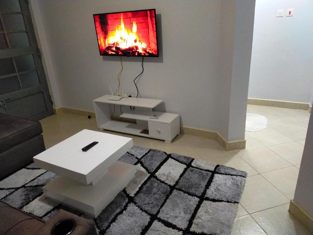 ein Wohnzimmer mit einem TV an der Wand in der Unterkunft One bedroom apartments tulivu in Thika