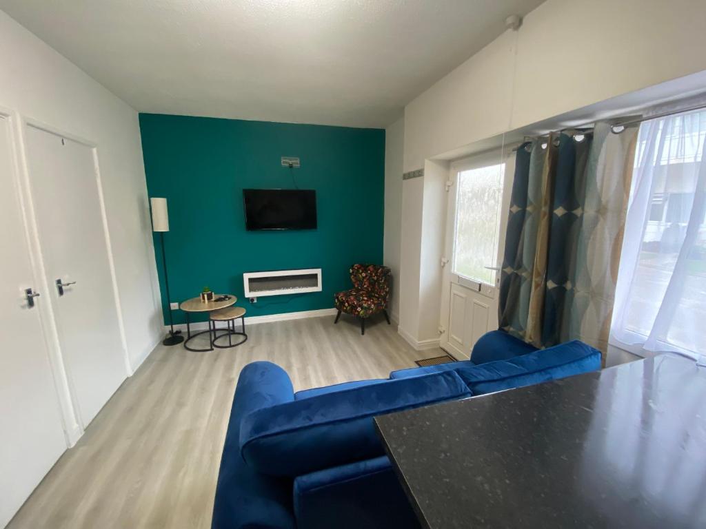 uma sala de estar com um sofá azul e uma televisão em Ground floor apartment Brean em Brean