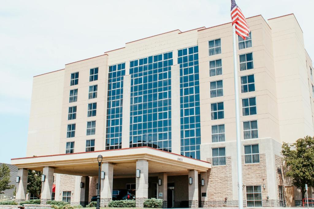 an office building with an american flag on top at Hotel Topeka at City Center in Topeka