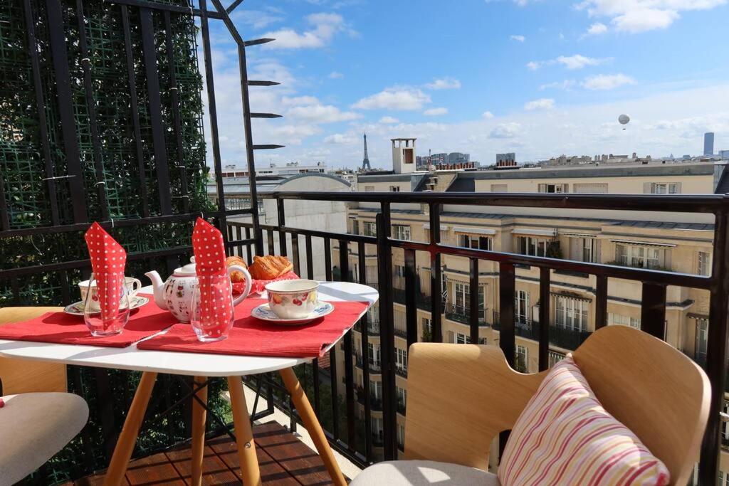 Eiffel Tower View Rooftop Studio في باريس: طاولة مع طبق من الطعام على شرفة