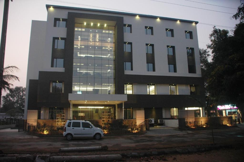 un coche blanco estacionado frente a un edificio en Hotel Kanan en Ahmedabad